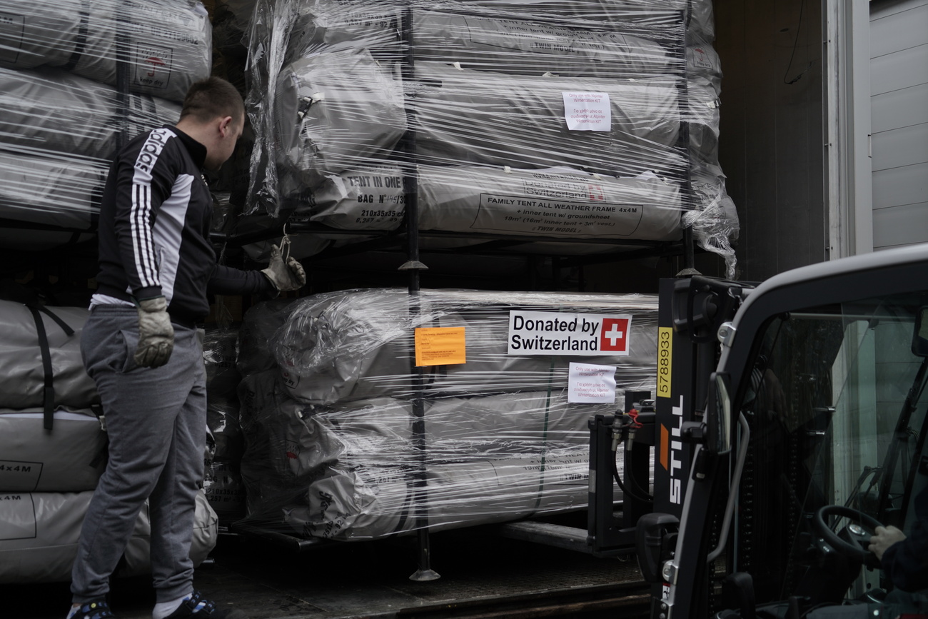 Scatole di aiuti umanitari con la scritta "Donated by Switzerland"