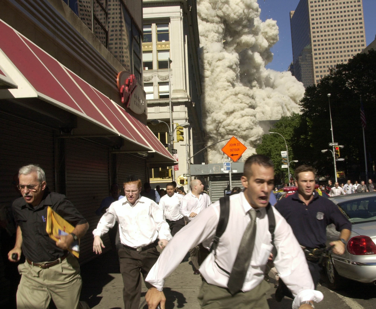 Con el derrumbe de las torres, una gigantesca nube de polvo, en parte tóxica, se extiende sobre el Bajo Manhattan. La gente huye presa del pánico.