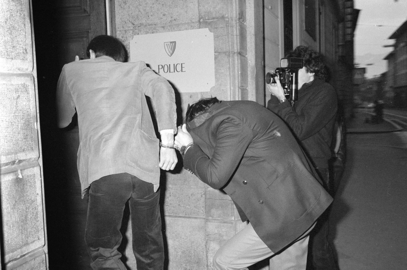 Two people enter a building with their faces covered