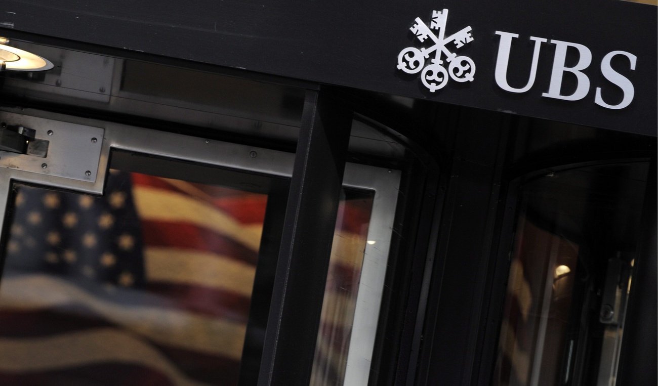 Il logo di UBS con dietro una bandiera USA.