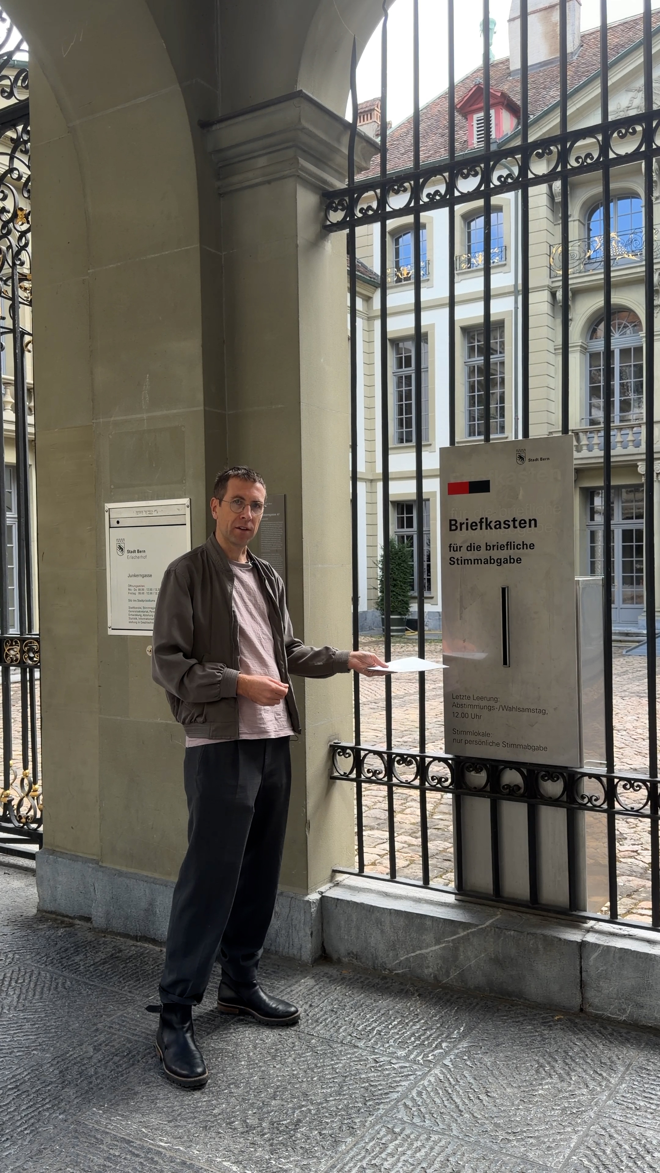 Photo of man posting an envelope in letter box