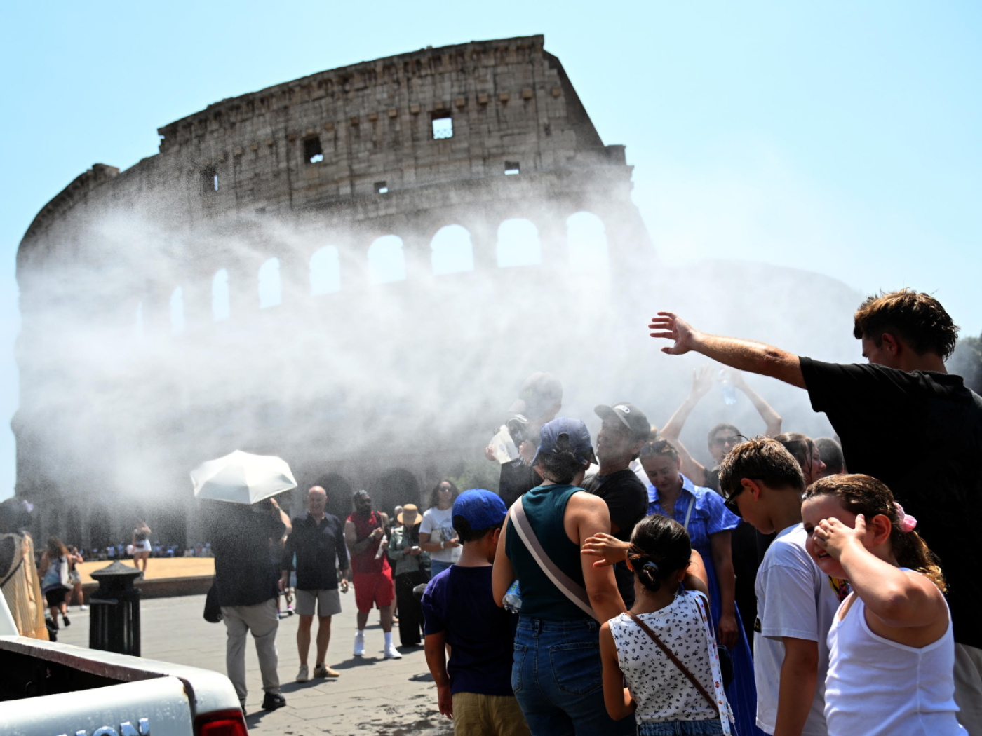 acqua vaporizzata su persone riunite davanti al colosseo di roma