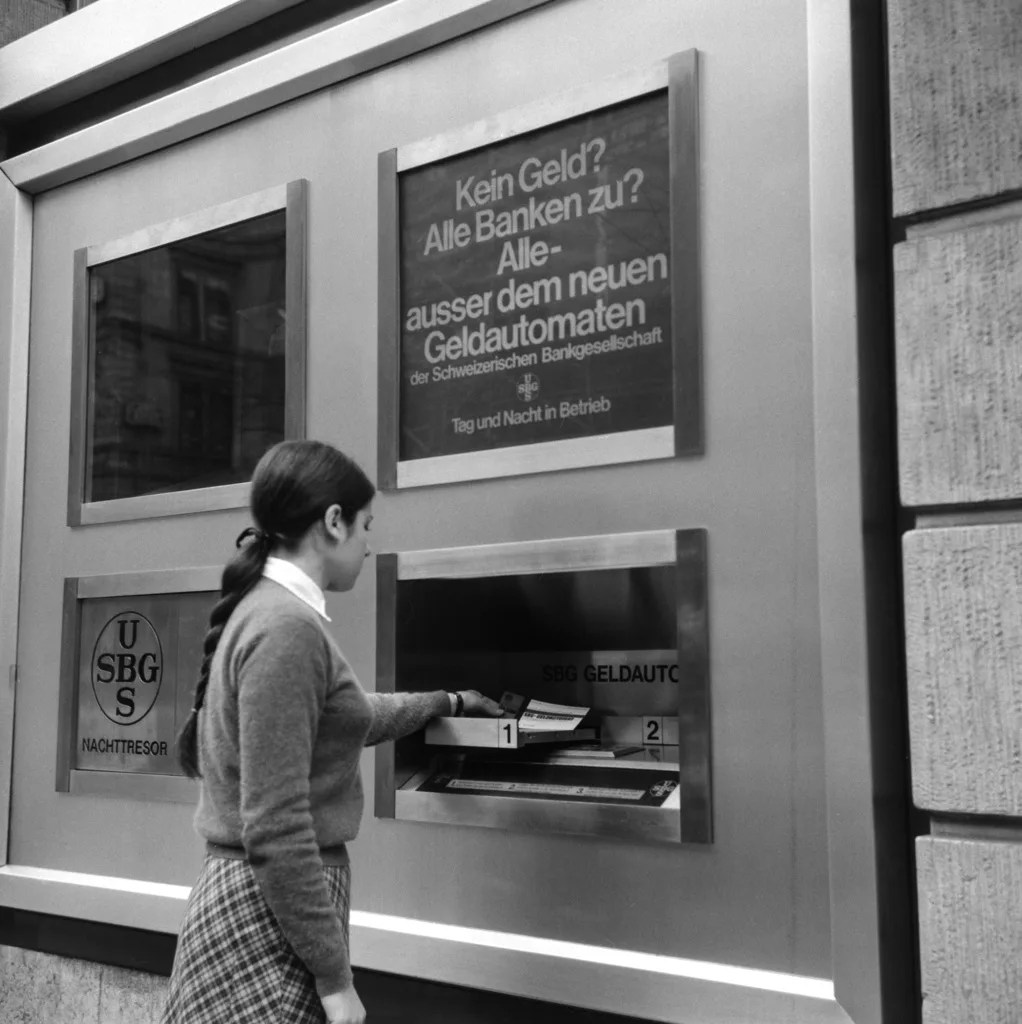Frau, die an einem Bancomaten Geld abhebt
