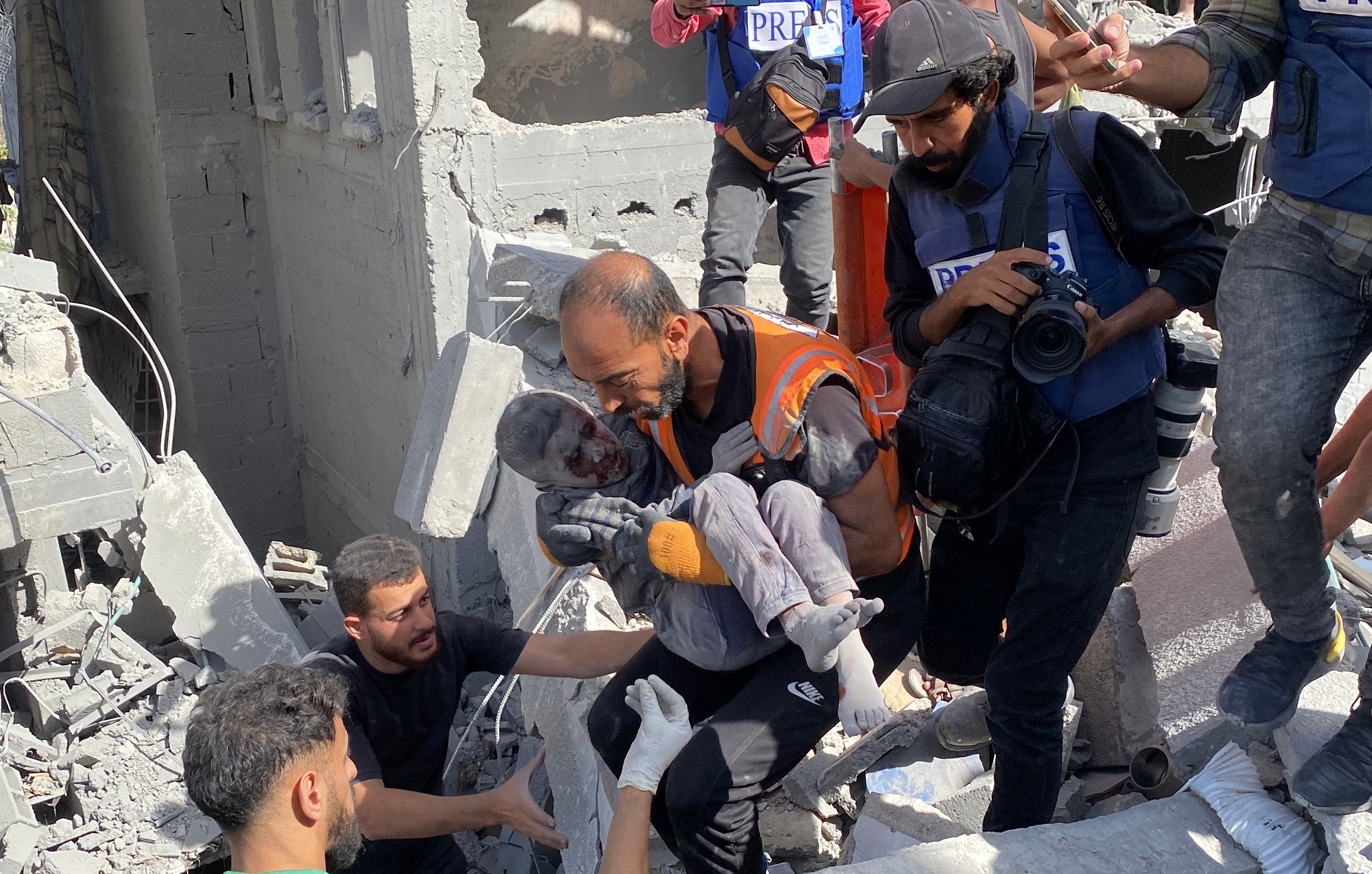People work to recover Palestinian casualties from the rubble of a house following an Israeli strike