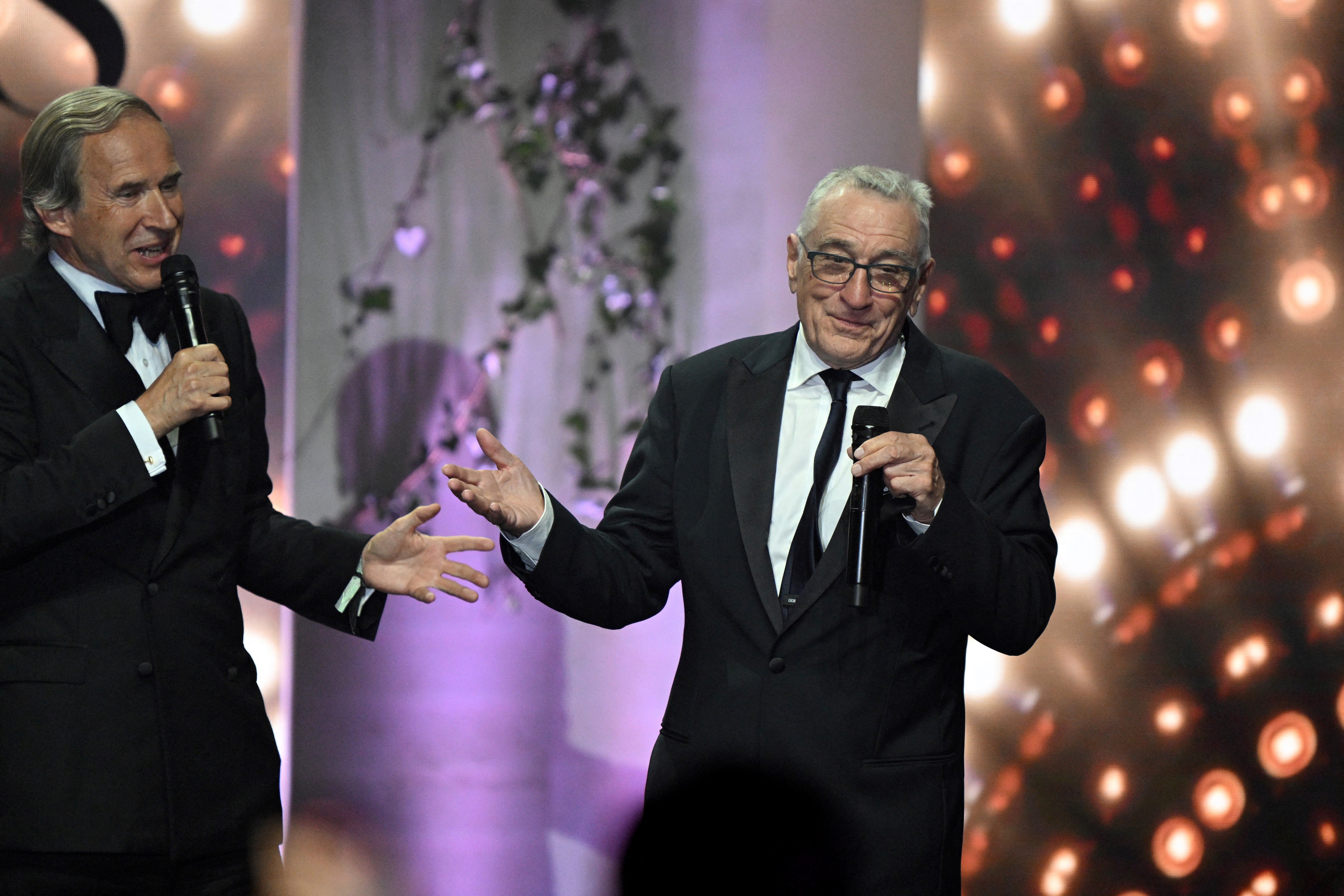 De Pury conducts an auction next to US actor Robert de Niro during the annual amfAR Cinema Against AIDS Cannes Gala in Cap d'Antibes, on the sidelines of the 75th Cannes Film Festival.