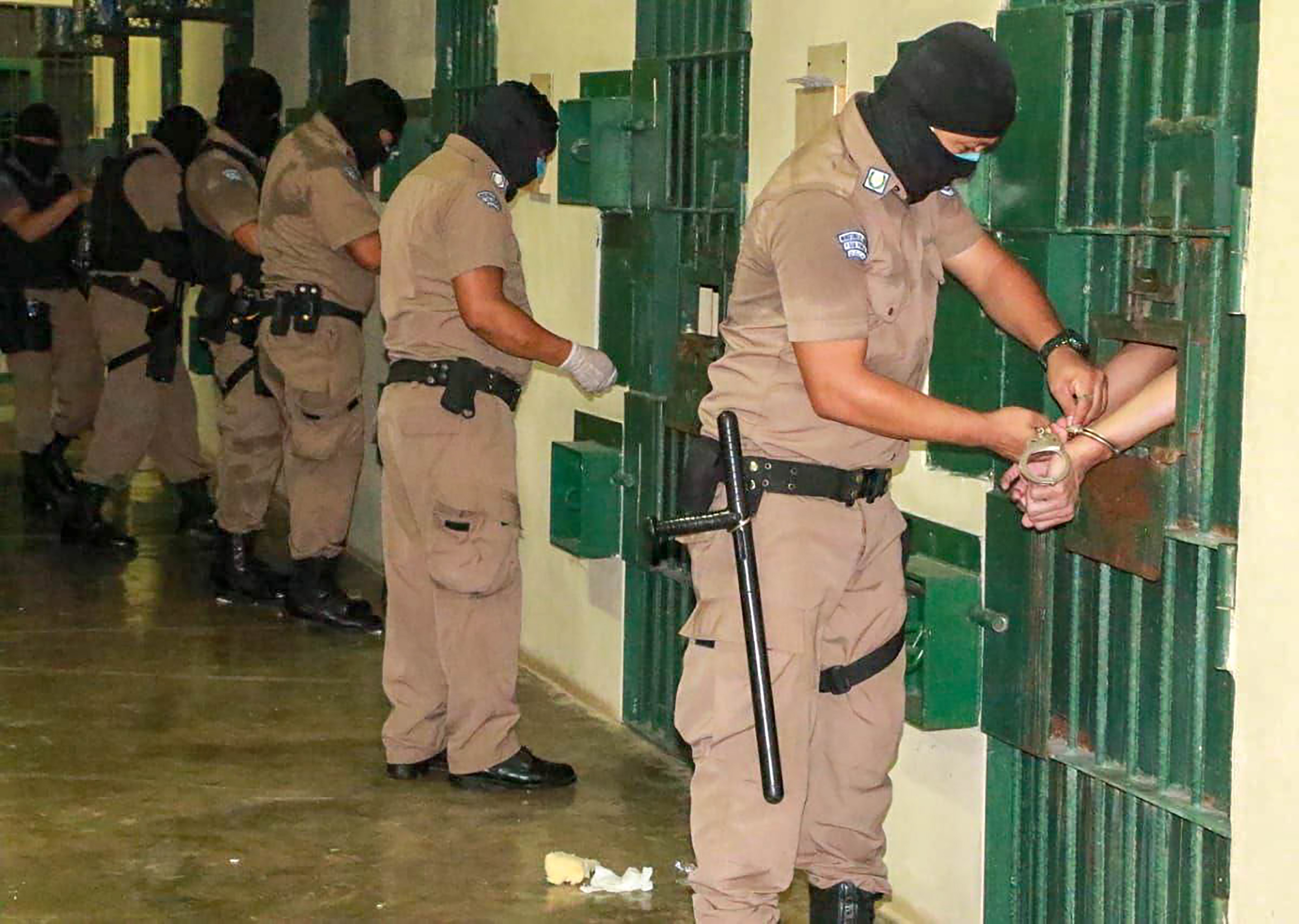 Un guardia inspecciona a miembros de pandillas recluidos en la prisión de máxima seguridad de Zacatecoluca, en El Salvador.