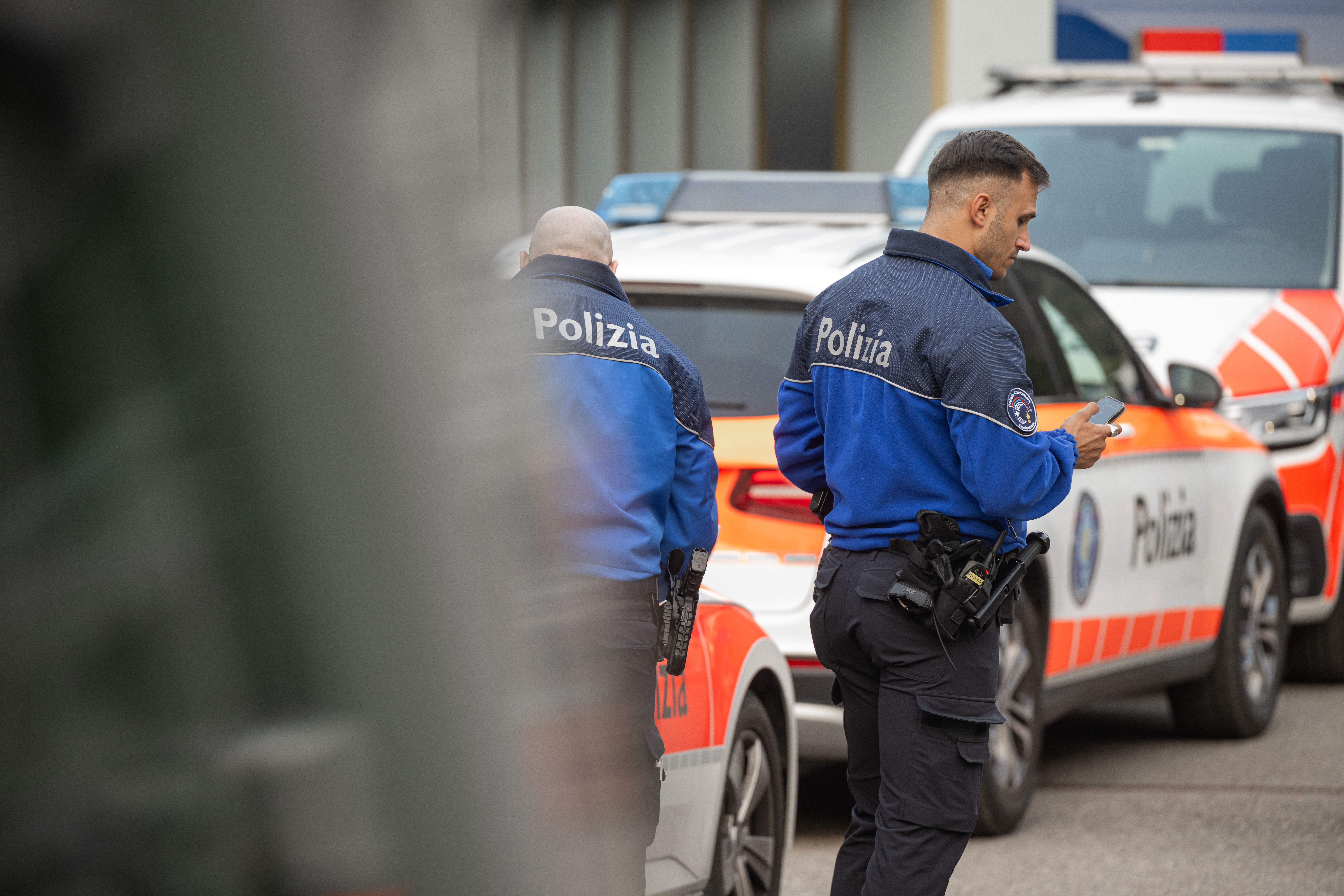 Un veicolo della polizia cantonale ticinese e due agenti.