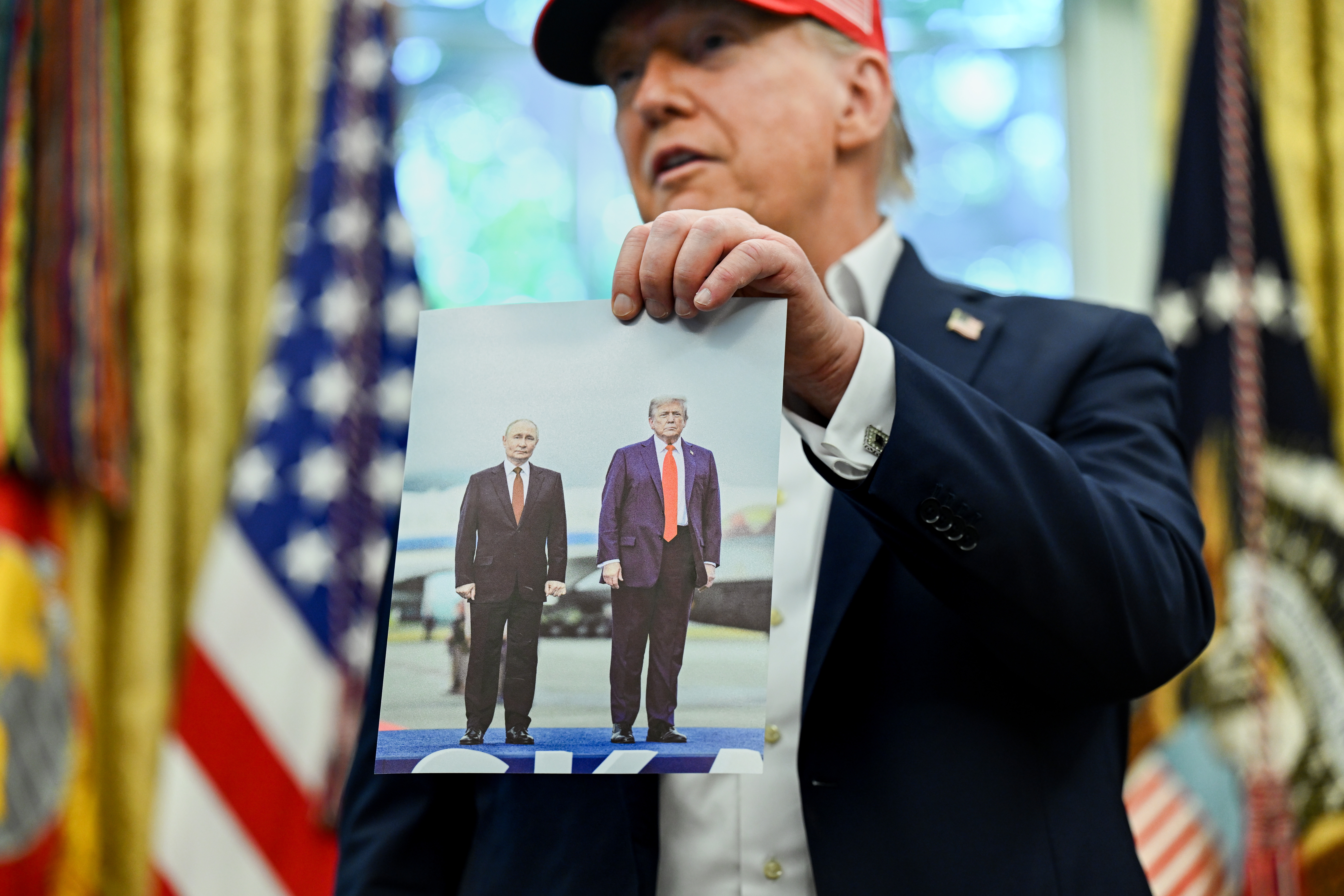 Trump holds up photo of him and Putin