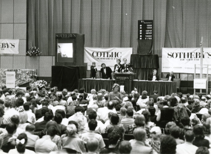 Black-and-white photo of a crowded Sotheby’s auction