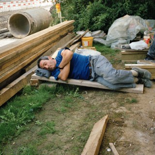 Mann schläft auf der Baustelle