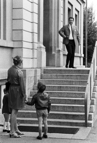 Mujer con un niño espera al pie de una escalinata