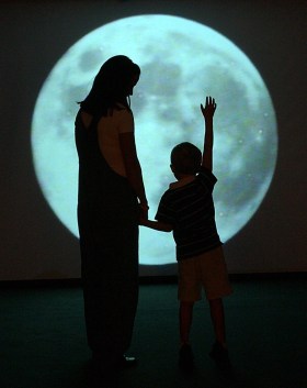 Mother and son in front of a giant moon