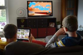 Deux enfants devant une télévision et une tablette.