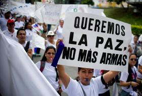 Manifestación por la paz en Colombia. Una mujer lleva una pancarta en la que se lee Queremos la paz, no más armas