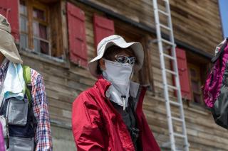 マッターホルン登山前、高度順応のため山小屋に滞在するサングラスとマスク姿の登山観光客