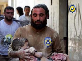 Syrischer Helfer trägt ein kleines Kind, das bei einem Bombenangriff verletzt wurde.