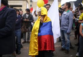 Una mujer envuelta con una bandera colombiana