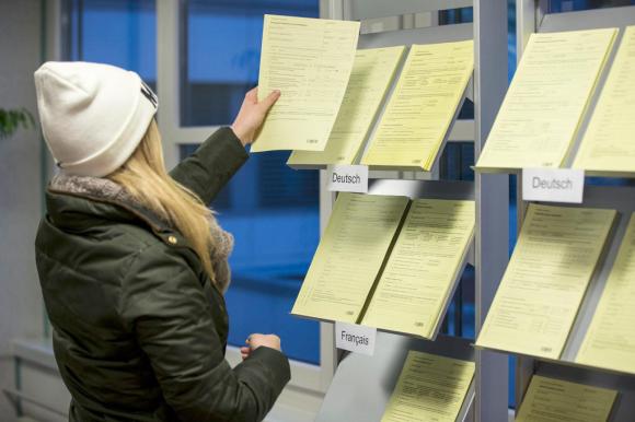 Una mujer toma un formulario en una oficina de colocaciones de empleos.