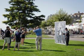 ヴヴェイで昨年行われた写真祭「Festival Images」に展示された自身の写真の横でポーズをとるアスワニさん