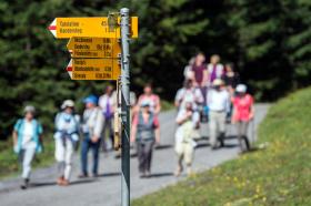 Tourists hike near mountain lake Oeschinensee above the tourist resort of Kandersteg in the Bernese Alps