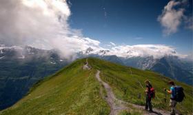 Two hikers on a mountain path near Planplatten above the village of Hasliberg in the Bernese Alps