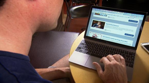 A man taps on a laptop computer.
