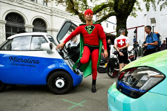 Un hombre disfrazado de superman en el rally de coches eléctricos