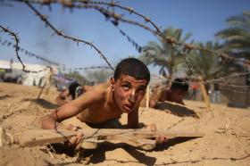 Palestinian boy takes part in a military-style summer camp
