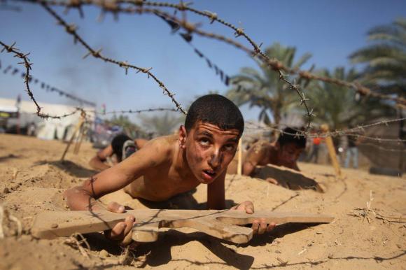 Palestinian boy takes part in a military-style summer camp