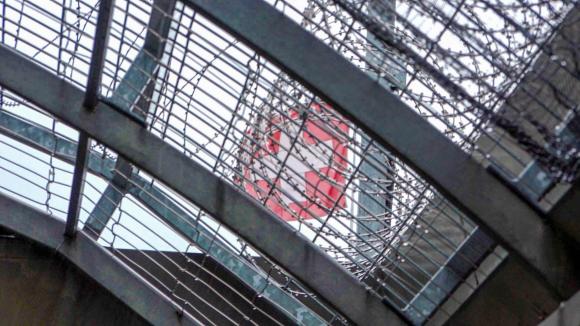Dachstock des Gefängnisses mit Blick auf Stacheldraht und Schweizer Flagge