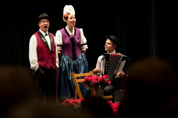 three people singing wearing tradtional dress