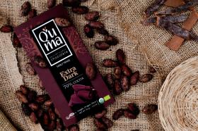 Une tablette de chocolat à côté de fèves de cacao.