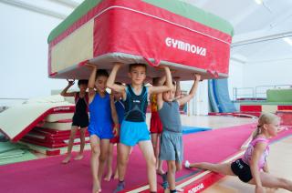 boy gymnasts carry mattress