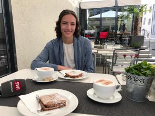 Woman sitting at a cafe with coffee and pastry