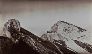 The historical mountain hotel, Pilatus Kulm, set against a mountain panorama backdrop, 1875.