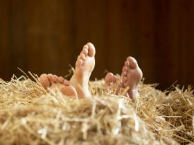 麦わらベットに横たわる大人と子どもの足
