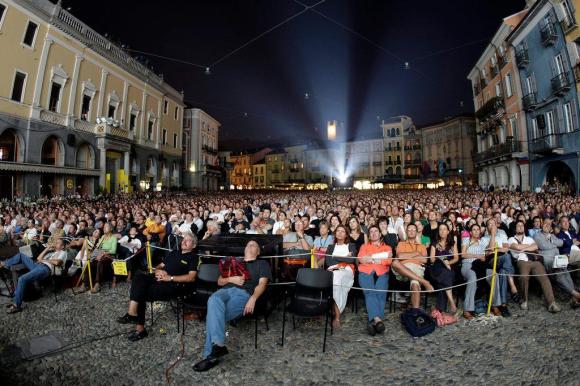 آلاف المتفرجين يُتابعون عرضا لشريط سينمائي في الهواء الطلق في بياتزا غراندي ، ساحة العرض الكبرى وسط مدينة لوكارنو