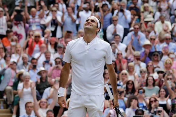 Federer schaut in die Höhe und lächelt dabei glücklich und gerührt über seinen Sieg. Im Hintergrund jubelt ein Publikum.