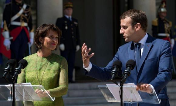 Doris Leuthard steht neben Emmanuel Macron an einem Rednerpult und lacht ihm zu.