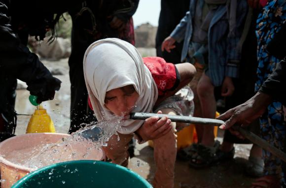 A girl drinks water from a well that is allegedly contaminated with cholera bacteria, on the outskirts of Sanaa, Yemen.