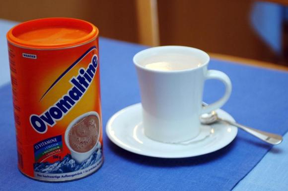 Can of Ovomaltine and a cup of milk