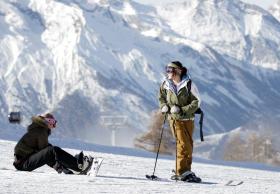 A skier and a snowboarder on a piste in Thyon