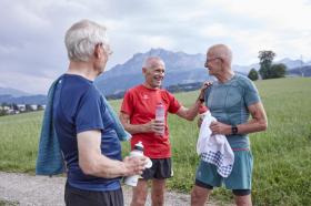 Drei Senioren machen einen Halt beim Joggen.