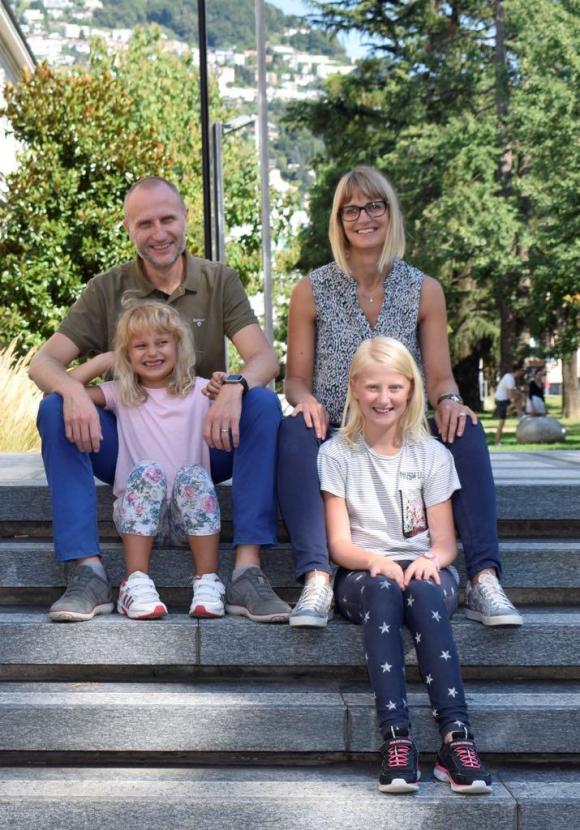 Le papa et la maman avec les deux petites filles, assis sur un banc.
