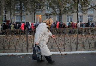Eine alte Frau mit Stock verlässt das Wahllokal in Varnita, Moldavien.