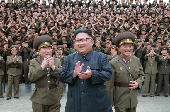 North Korean leader Kim Jong-un acknowledges a welcome from military from military officers during a visit