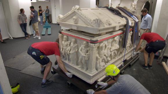 Sarcophagus being carried.