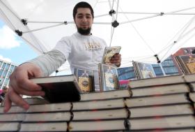 Un ragazzo dispone dei libri del Corano su uno stand