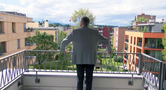 Man standing on terrace of apartment building