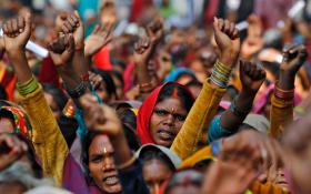 手を突き上げて抗議するインドの女性たちの写真